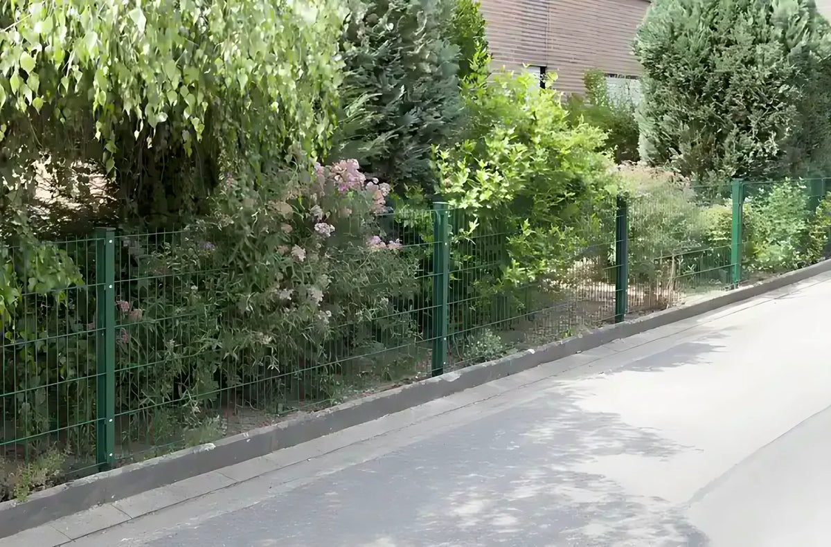Doppelstabmattenzaun in Moosgrün mit Zaunpfosten als Grundstücksbegrenzung im Garten