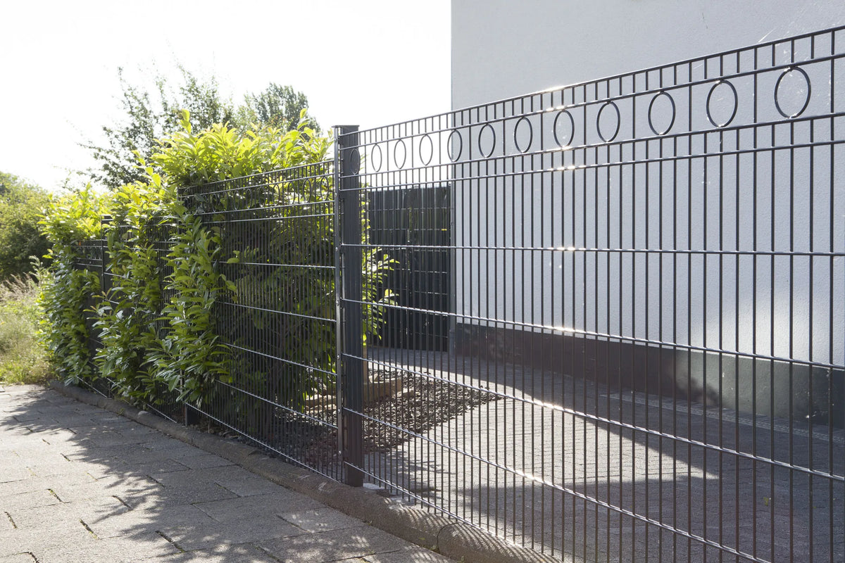 Schmuckzaun Rom in Anthrazit an einer Grundstücksgrenze mit Hecke