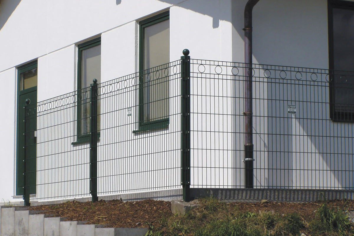 Schmuckzaun Rom in Anthrazit mit Kreisornamenten vor einer weißen Hauswand