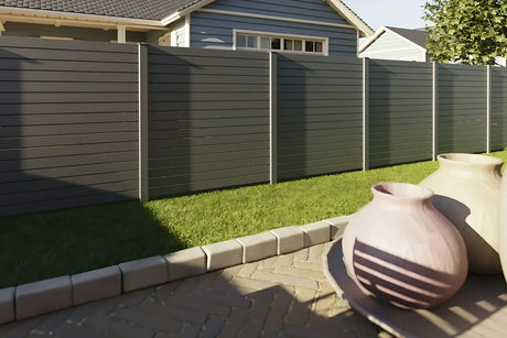 Alu-Rhombuszaun pure 100 in Anthrazit als Sichtschutz entlang einer Terrasse mit Rasen