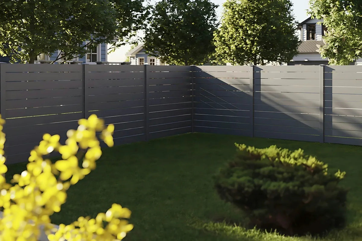 Alu-Sichtschutzzaun line 150 in Anthrazit rund um einen Garten mit Rasen und Sträuchern