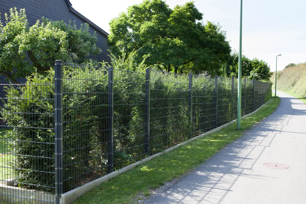 Metallzaun 6/5/6 in Anthrazit entlang eines Gehwegs neben einer Hecke