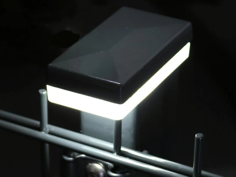 LED-Pfostenkappe aus dem Set leuchtet auf einem Zaunpfosten am Doppelstabmattenzaun