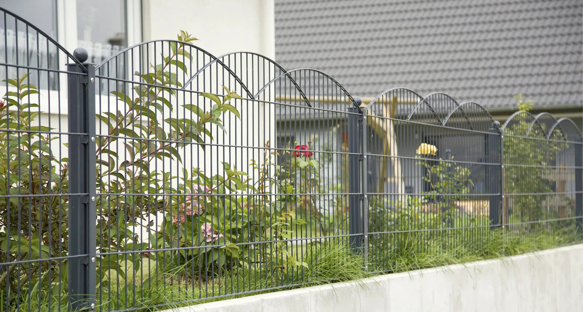 Schmuckzaun Innsbruck in Anthrazit auf einer Sockelmauer vor einem Wohnhaus