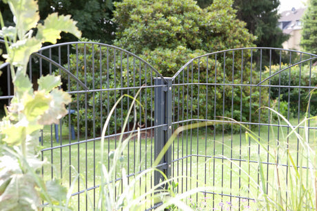 Schmuckzaun Innsbruck in Anthrazit mit Zaunpfosten hinter Gartenpflanzen