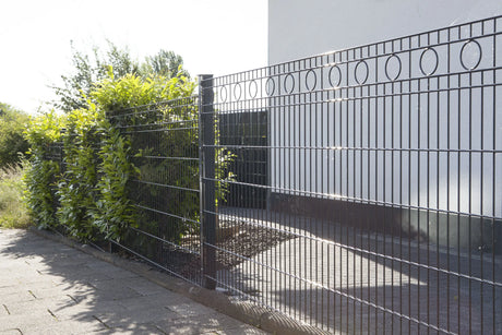 Schmuckzaun Rom in Anthrazit an einer Grundstücksgrenze mit Hecke