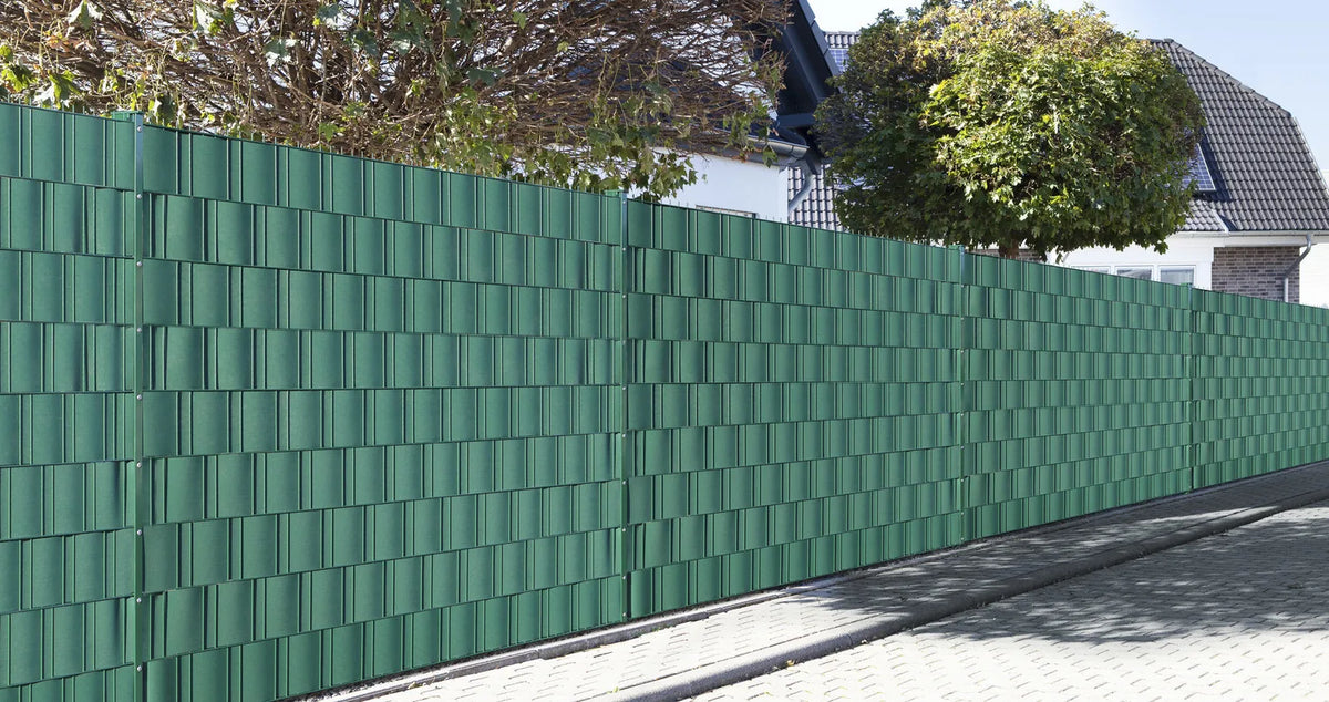 Doppelstabmattenzaun mit grünen Sichtschutzstreifen aus Polypropylen entlang des Gehwegs